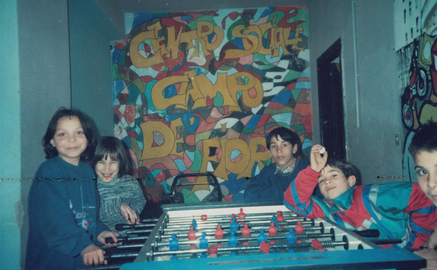 Bambini al biliardino davanti al murale del Centro Sociale