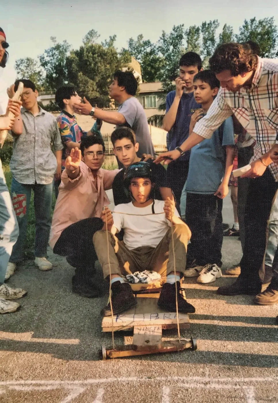 Un ragazzo con il casco seduto sul carretto di legno, pronto a partire