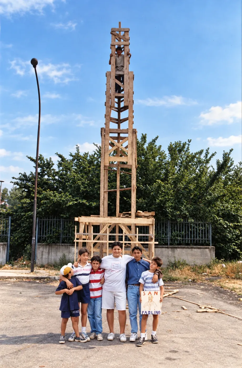 Bambini davanti al Giglio di legno costruito insieme, un ragazzo in cima