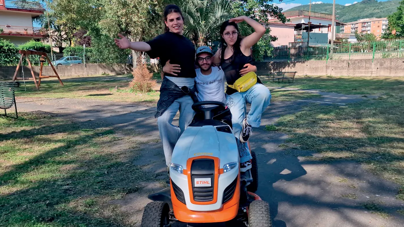 Volontari sorridenti sul trattorino tosaerba al Parco Paolino Avella