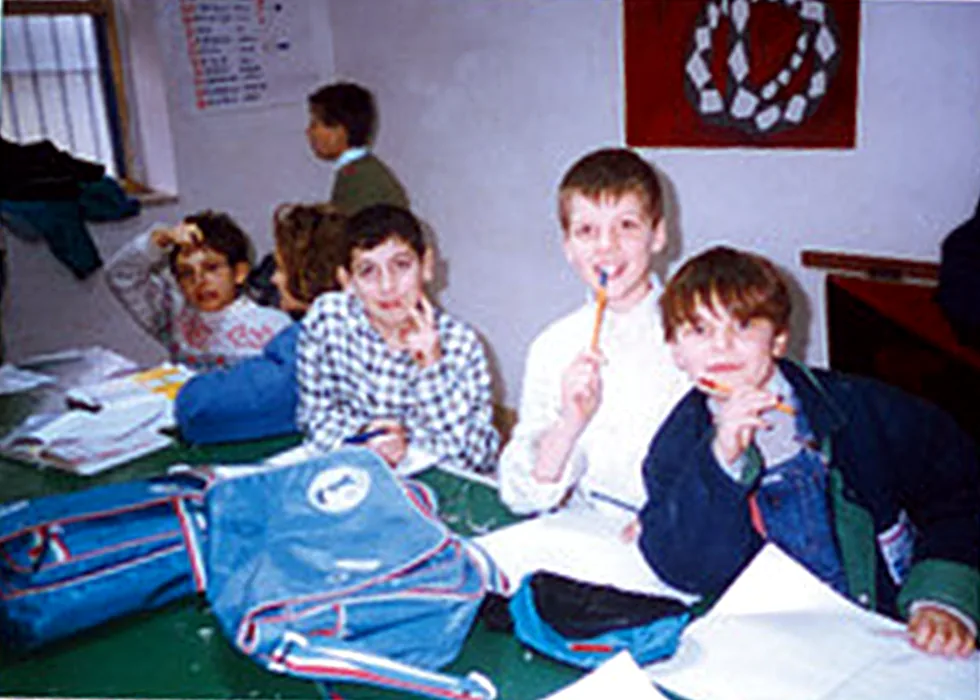 Bambini al tavolo del doposcuola con zaini e quaderni
